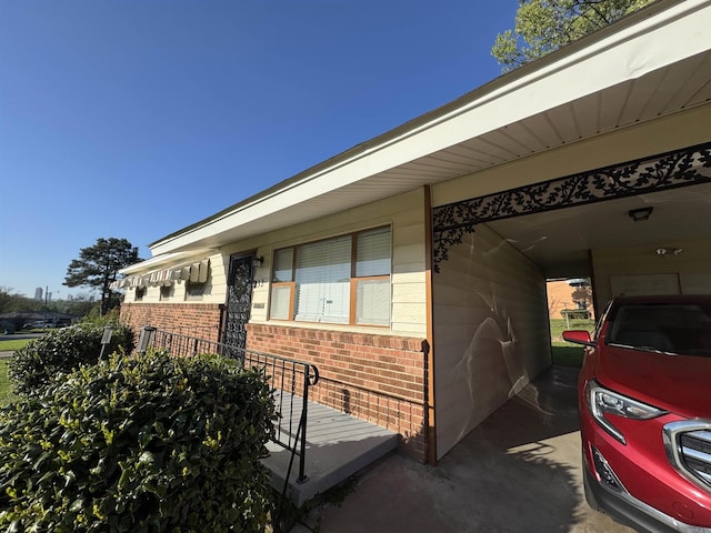view of side of property featuring a carport and brick siding