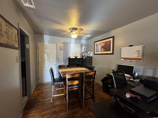 dining space with dark wood-type flooring, visible vents, baseboards, and a ceiling fan