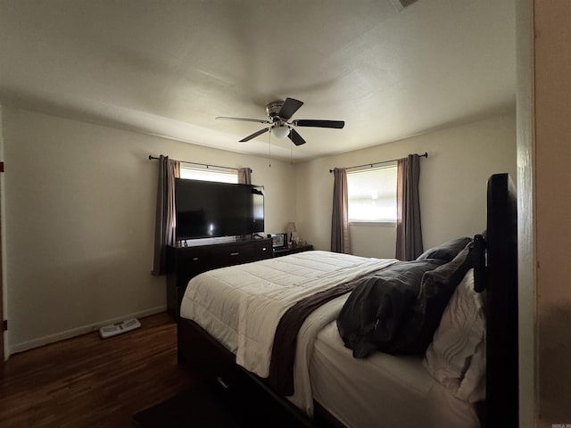 bedroom with ceiling fan, multiple windows, baseboards, and dark wood-style floors