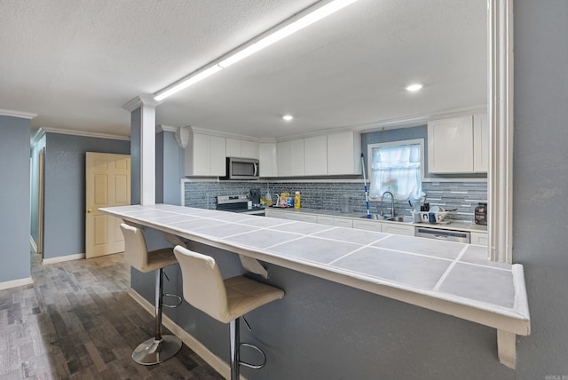 580 Providence Loop, Malvern, AR 72104 - kitchen with stainless steel appliances, tasteful backsplash, a kitchen bar, and tile counters