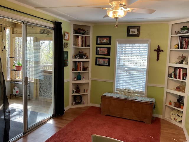 living area featuring wood finished floors, a ceiling fan, and plenty of natural light