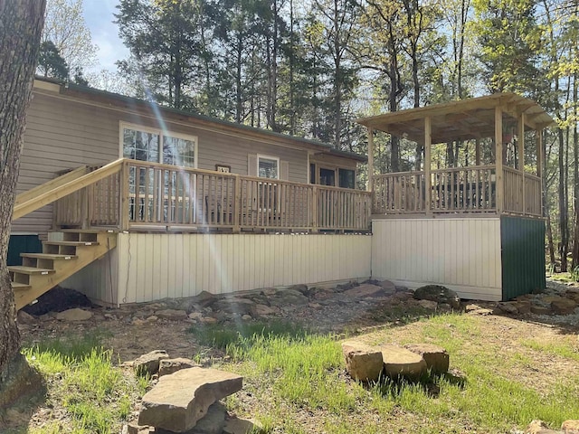 rear view of house with stairs and a wooden deck