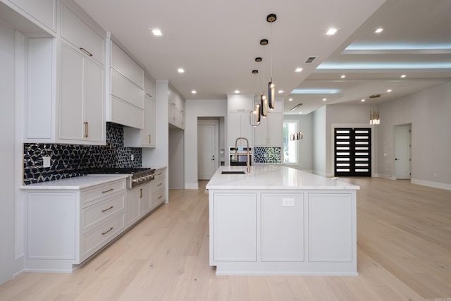 221 Abington Cir, Little Rock, AR 72223 - kitchen featuring tasteful backsplash, white cabinets, light wood-style floors, and a sink