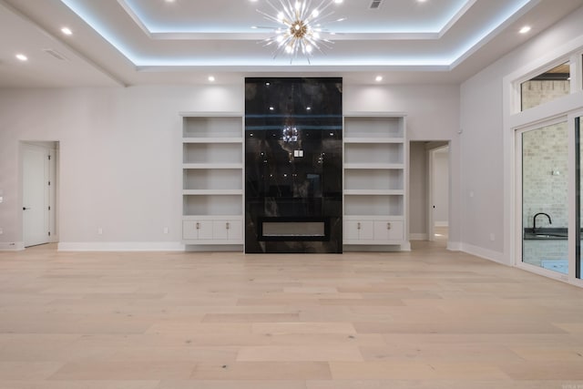 221 Abington Cir, Little Rock, AR 72223 - unfurnished living room featuring a tray ceiling, recessed lighting, an inviting chandelier, and wood finished floors