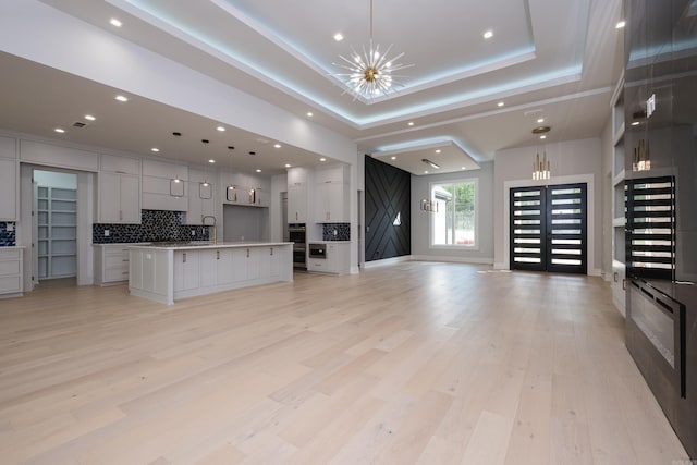 221 Abington Cir, Little Rock, AR 72223 - kitchen with open floor plan, light wood-style floors, recessed lighting, a center island with sink, and backsplash