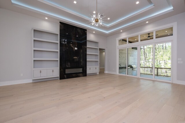 221 Abington Cir, Little Rock, AR 72223 - unfurnished living room with a tray ceiling, baseboards, and light wood-style floors