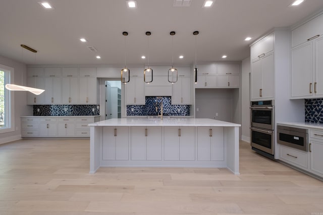 221 Abington Cir, Little Rock, AR 72223 - kitchen featuring white cabinets, light countertops, double oven, a spacious island, and backsplash