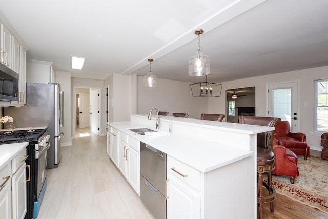104 Dickson Dr, Little Rock, AR 72207 - kitchen with a breakfast bar, a sink, stainless steel appliances, open floor plan, and a center island with sink