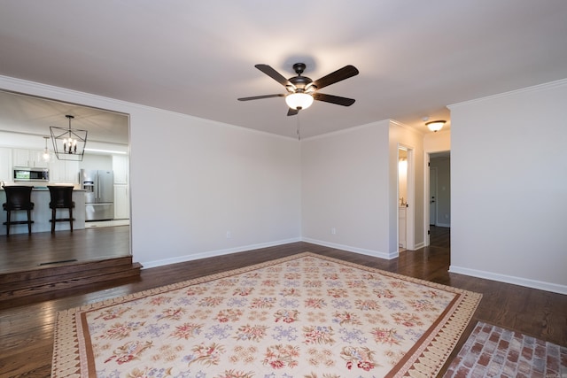 104 Dickson Dr, Little Rock, AR 72207 - spare room featuring dark wood-style flooring, ceiling fan with notable chandelier, baseboards, and ornamental molding
