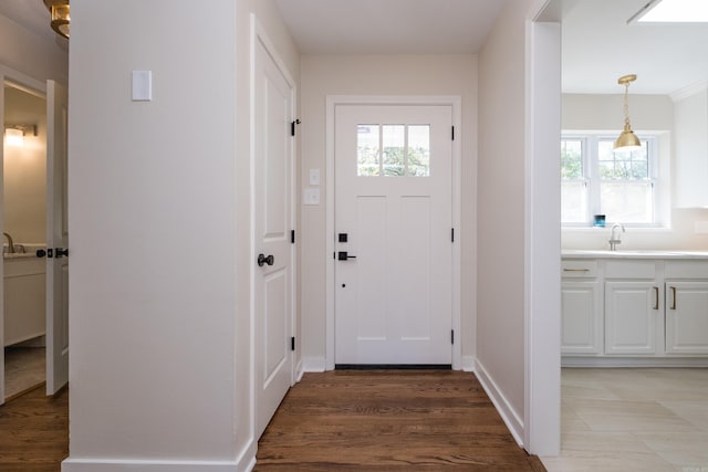 104 Dickson Dr, Little Rock, AR 72207 - doorway to outside featuring a sink, baseboards, and light wood finished floors