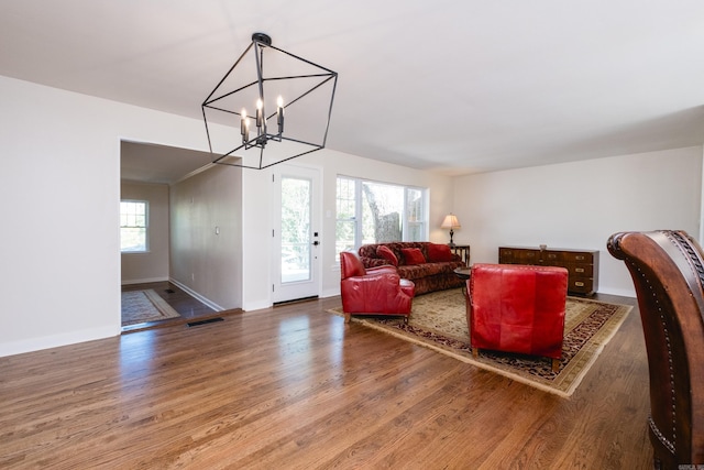 104 Dickson Dr, Little Rock, AR 72207 - living area featuring wood finished floors, an inviting chandelier, baseboards, and visible vents