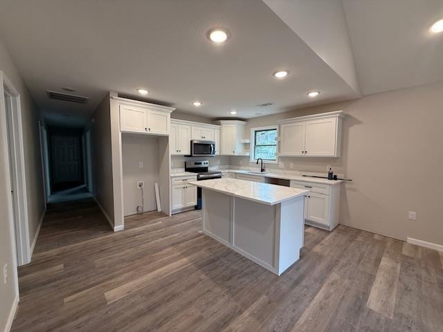 615 N Pruett, Paragould, AR 72450 - kitchen with wood finished floors, white cabinets, baseboards, light countertops, and appliances with stainless steel finishes