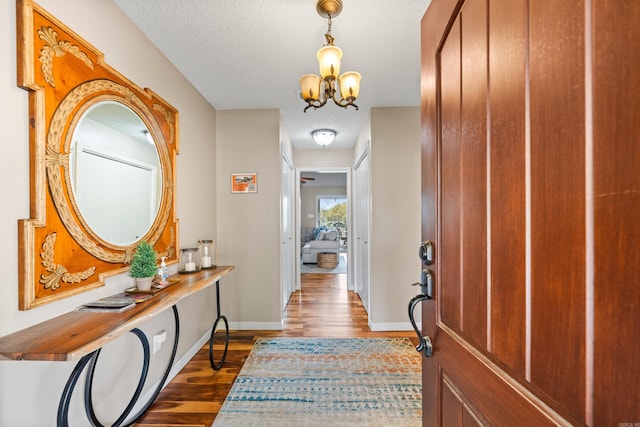166 Heatherwood, Hot Springs, AR 71913 - foyer with a textured ceiling, an inviting chandelier, baseboards, and dark wood finished floors