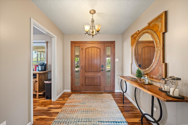 166 Heatherwood, Hot Springs, AR 71913 - entrance foyer featuring a notable chandelier, a textured ceiling, baseboards, and dark wood-style floors