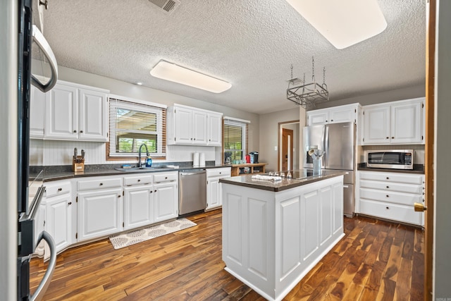 166 Heatherwood, Hot Springs, AR 71913 - kitchen with a center island, dark countertops, white cabinets, stainless steel appliances, and a sink