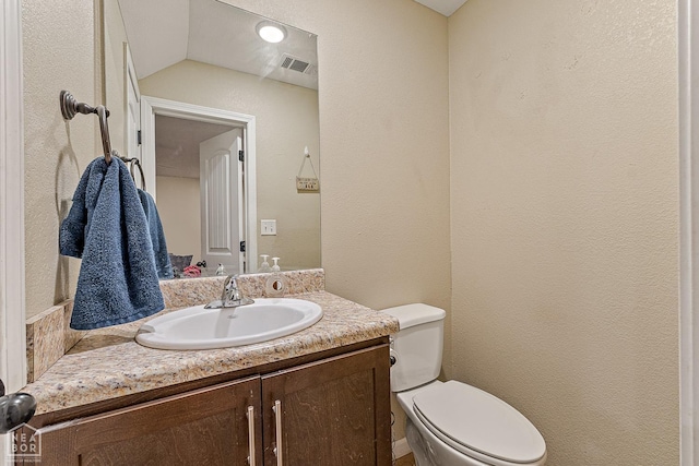 1104 Cartwright, Jonesboro, AR 72401 - half bath featuring visible vents, toilet, vanity, and vaulted ceiling