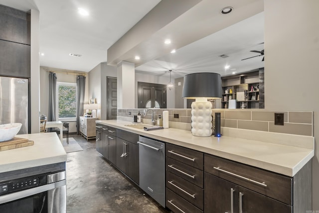 kitchen featuring dark brown cabinetry, decorative backsplash, stainless steel appliances, finished concrete floors, and a sink