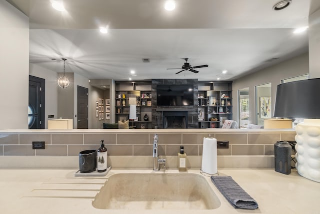 kitchen featuring visible vents, a sink, ceiling fan, a fireplace, and recessed lighting