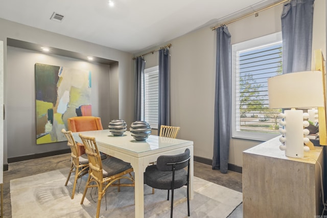 dining space featuring concrete floors, visible vents, and baseboards