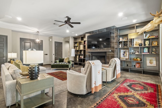living room featuring a ceiling fan, visible vents, recessed lighting, a tile fireplace, and built in shelves