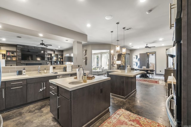 kitchen with open floor plan, a center island with sink, ceiling fan, and concrete flooring
