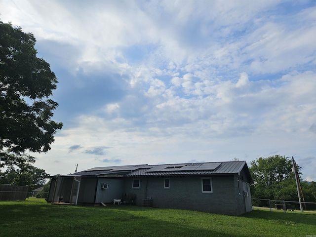 1139 Crescent Dr, Mena, AR 71953 - back of property with central AC, fence, a lawn, and solar panels