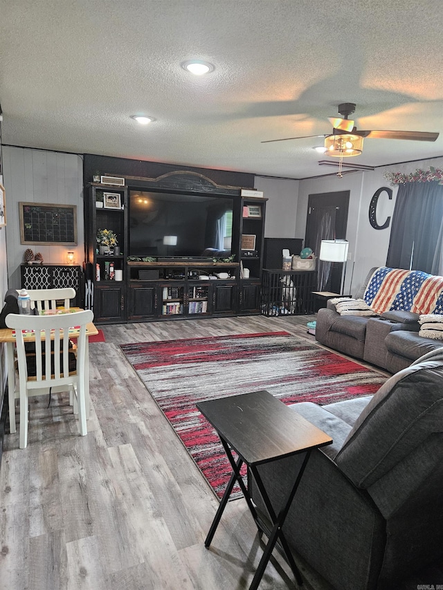 1139 Crescent Dr, Mena, AR 71953 - living area featuring ceiling fan, wood finished floors, and a textured ceiling