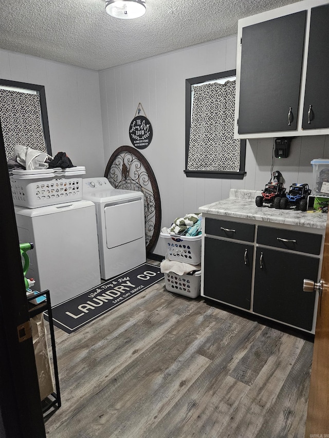 1139 Crescent Dr, Mena, AR 71953 - washroom featuring independent washer and dryer, a textured ceiling, wood finished floors, and cabinet space