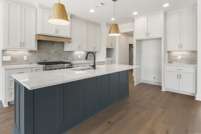 kitchen featuring range, dark wood-type flooring, white cabinetry, visible vents, and a sink