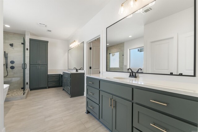 full bath featuring a sink, visible vents, two vanities, and a shower stall