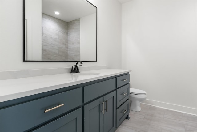 full bath featuring toilet, vanity, baseboards, and recessed lighting