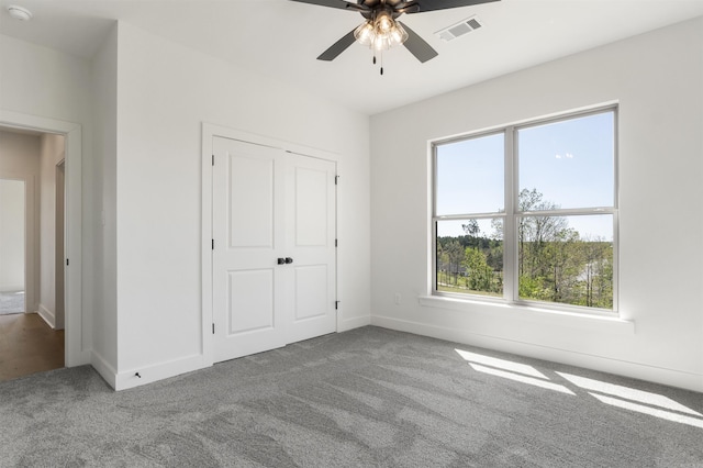 unfurnished bedroom with ceiling fan, carpet, a closet, visible vents, and baseboards