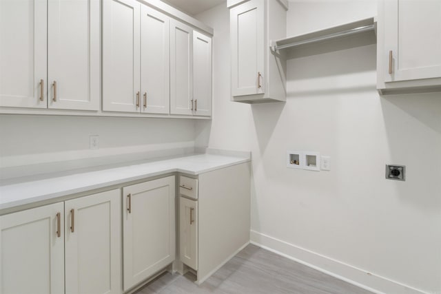 clothes washing area with light wood-style floors, hookup for a washing machine, hookup for an electric dryer, baseboards, and cabinet space