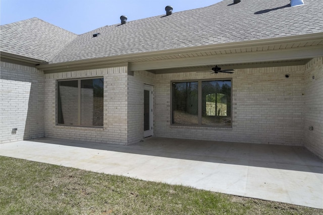rear view of house featuring roof with shingles, a patio, a ceiling fan, and brick siding