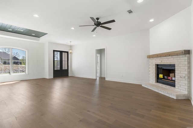 unfurnished living room featuring visible vents, baseboards, a ceiling fan, and dark wood finished floors