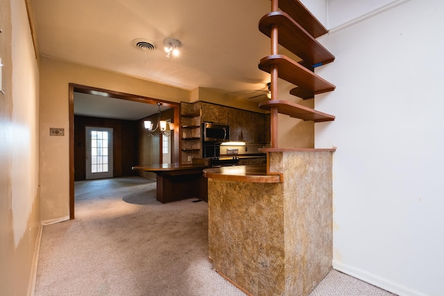 kitchen featuring visible vents, open shelves, a peninsula, carpet floors, and stainless steel microwave