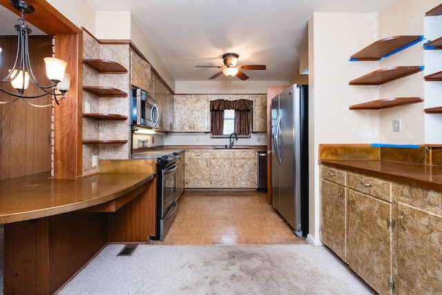 kitchen with a sink, ceiling fan with notable chandelier, open shelves, and stainless steel appliances