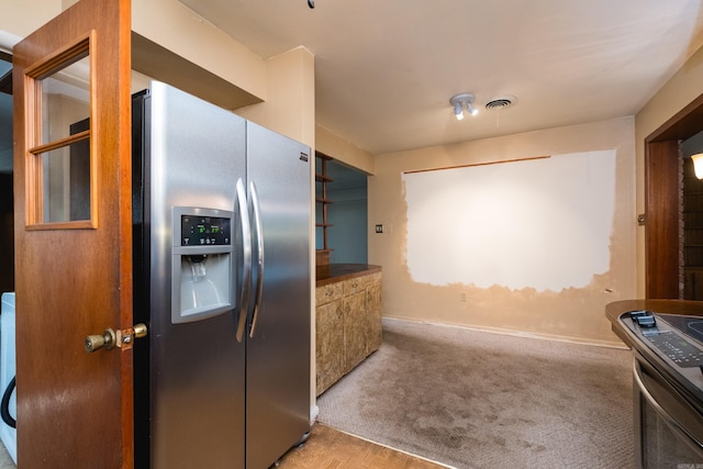 kitchen featuring baseboards, carpet, visible vents, and stainless steel refrigerator with ice dispenser