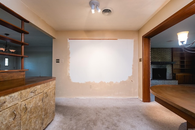unfurnished dining area featuring a fireplace, visible vents, baseboards, and carpet floors