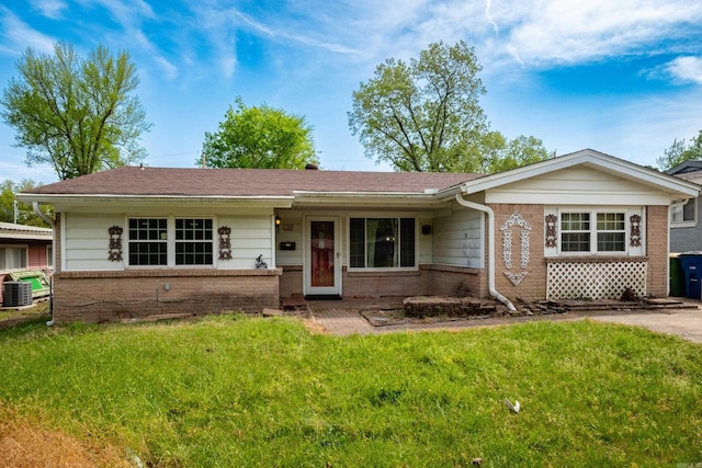 single story home with brick siding, a front lawn, and central air condition unit