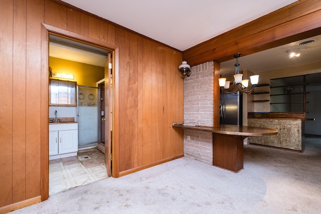bar with refrigerator with ice dispenser, visible vents, a sink, wooden walls, and a notable chandelier
