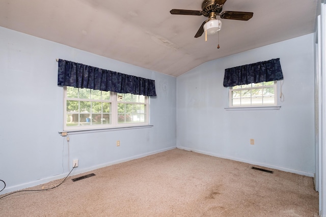 carpeted empty room featuring a ceiling fan, baseboards, vaulted ceiling, and visible vents
