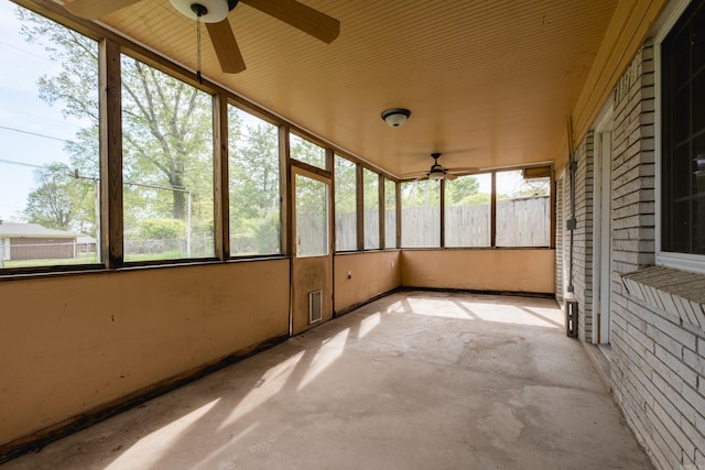 unfurnished sunroom featuring a ceiling fan