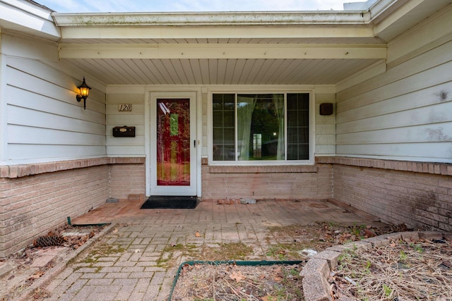 doorway to property with brick siding