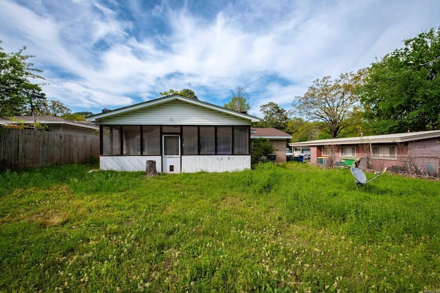 back of house featuring fence and a sunroom