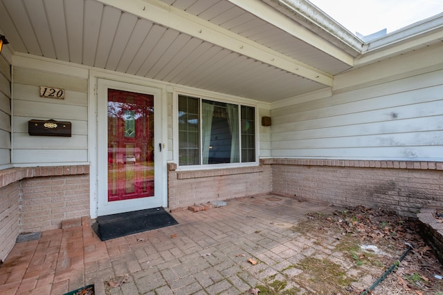 view of exterior entry with brick siding