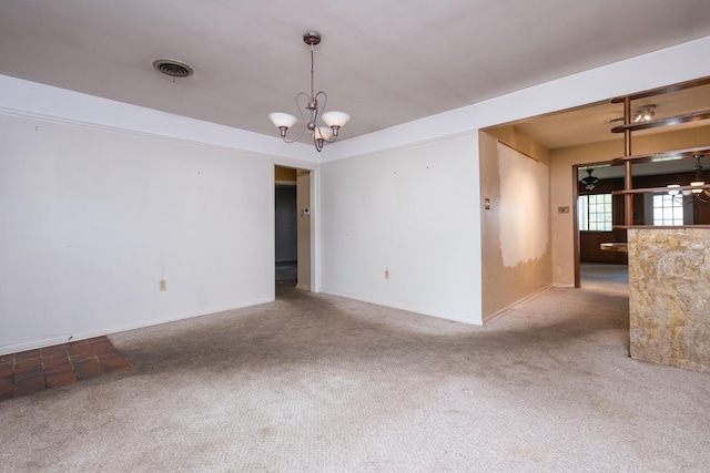 carpeted empty room with a chandelier, baseboards, and visible vents