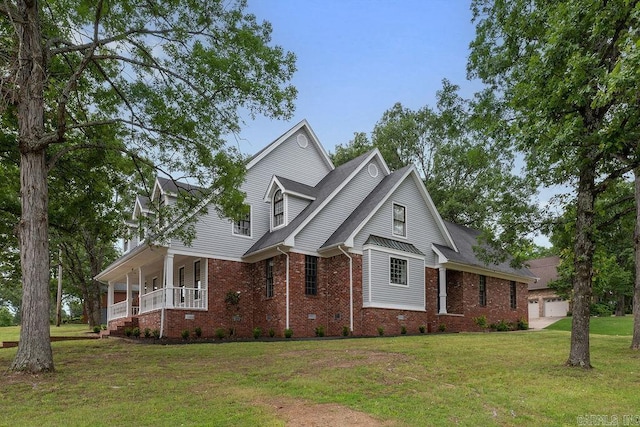 traditional home featuring brick siding, covered porch, and a front lawn