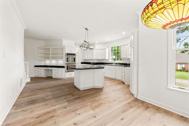 kitchen featuring stainless steel double oven, crown molding, dark countertops, open shelves, and light wood finished floors