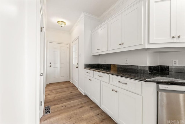 kitchen featuring stainless steel dishwasher, ornamental molding, white cabinets, light wood-type flooring, and dark stone countertops